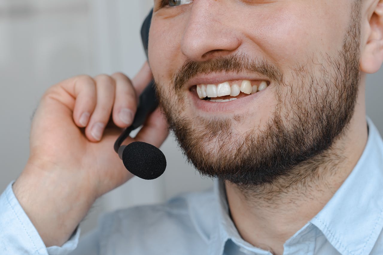 services-01 Close-up of a smiling customer support agent wearing a headset microphone.