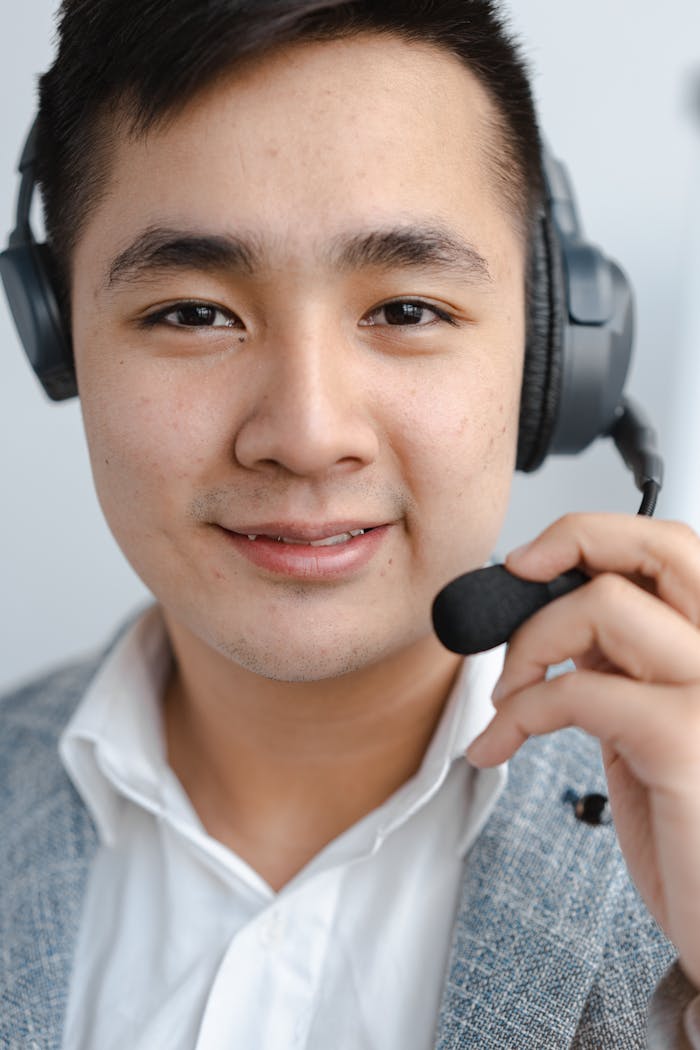 services-04 Close-up of a call center agent smiling while wearing a headset microphone.