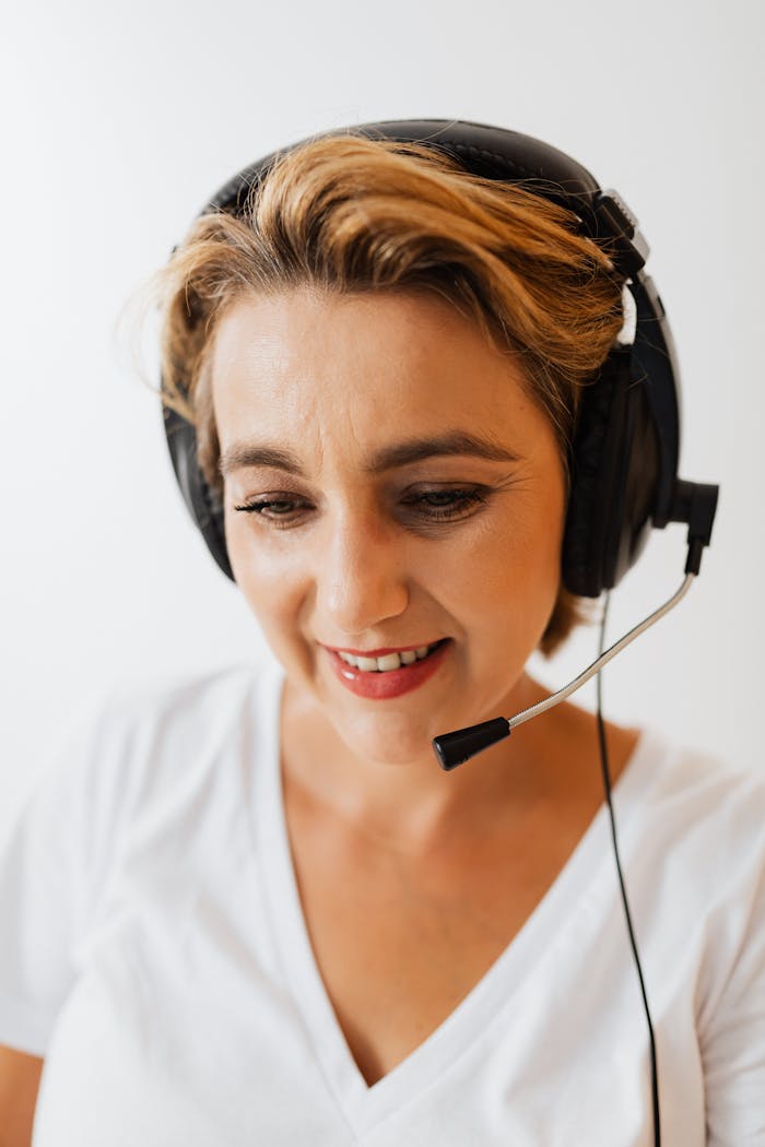 services-03 A woman wearing a headset smiles while working in customer service.